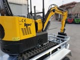 JPC HT-12 mini excavator on a trailer, rear three-quarter view