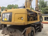 Escavadora de rodas Caterpillar M320D2 de 2017, vista traseira com motor aberto