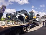 2026 Hyundai R210 crawler excavator on a flatbed trailer, side view