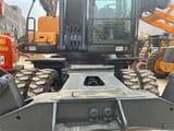 2023 Hyundai R210W-9S wheel excavator, front-facing view of the undercarriage and cab