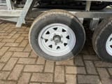 JPC HT-12 mini excavator on trailer, close-up of trailer wheel