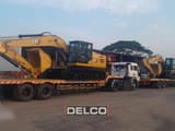 2026 Caterpillar 324 crawler excavator on a flatbed trailer, side view