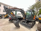 2026 Develon DX60D-10 mini excavator, front three-quarter view