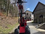 2023 Schäffer 2628 mini excavator, front view with raised loader arms