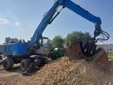 2017 Fuchs MHL320 material handler, side view with orange peel grapple