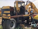 1999 Caterpillar M312 wheel excavator rear three-quarter view