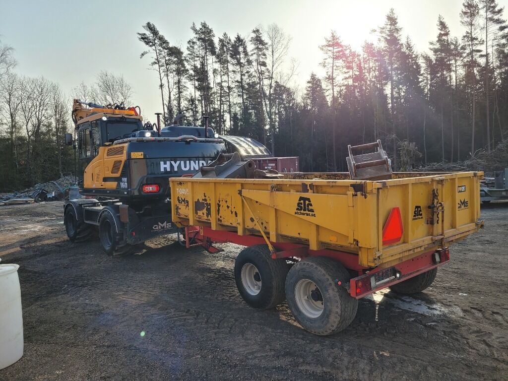 2018 Hyundai HW160 wheel excavator towing a yellow trailer