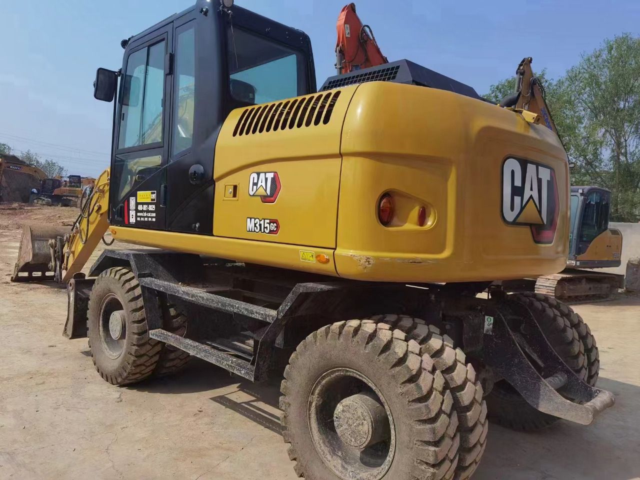 2023 Caterpillar M315GC wheel excavator, rear three-quarter view