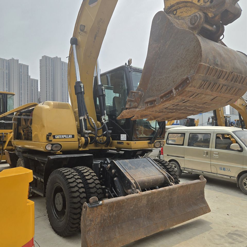 Escavadora de rodas Caterpillar M320D2 de 2017, vista dianteira a três quartos Escavadora de rodas Caterpillar M320D2 de 2017, vista dianteira a três quartos