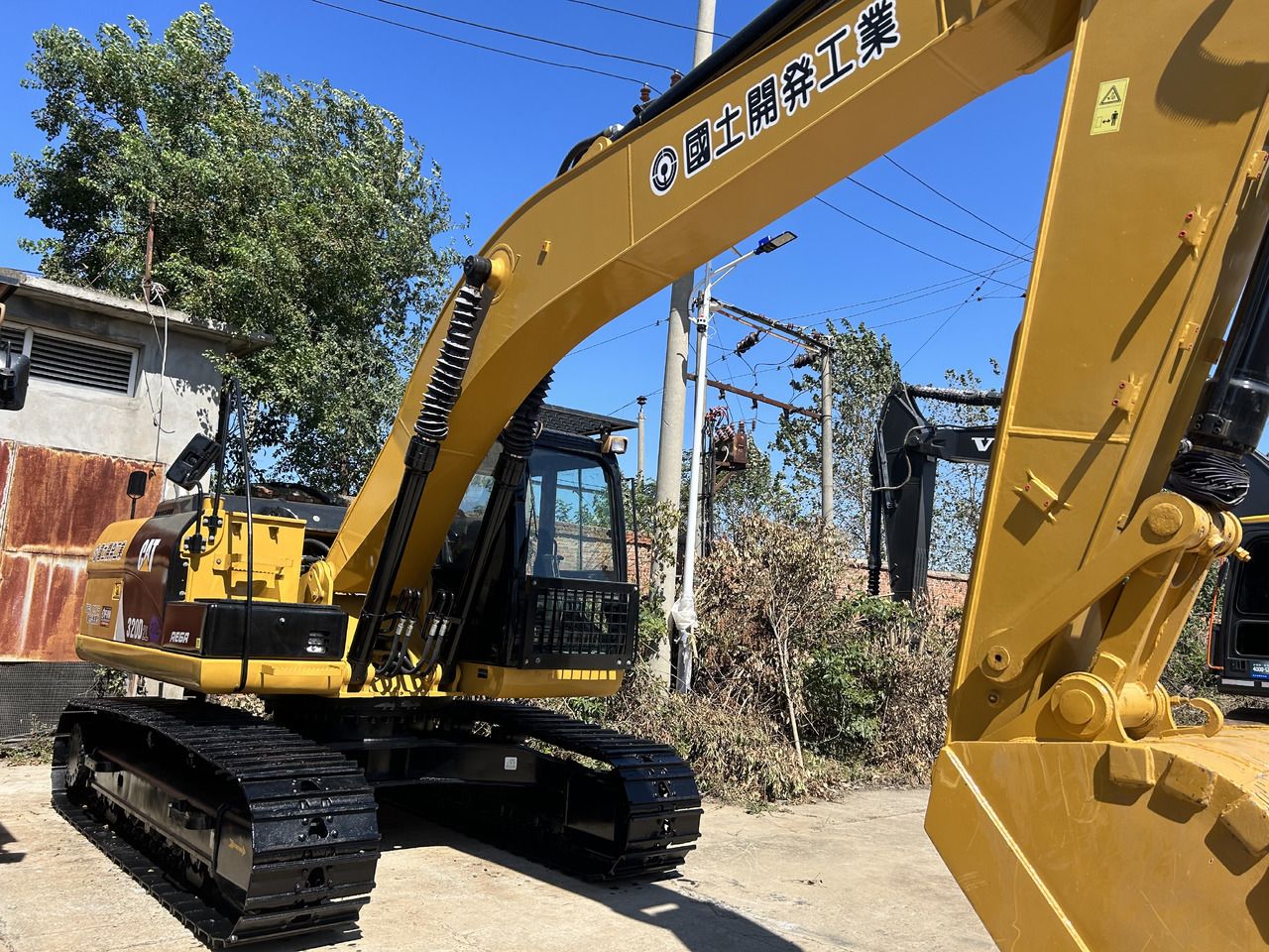 Escavatore cingolato Caterpillar 320DL del 2025, vista posteriore tre quarti Escavatore cingolato Caterpillar 320DL del 2025, vista posteriore tre quarti