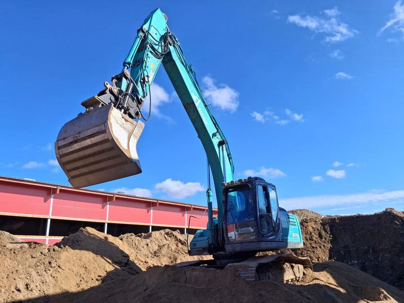 2016 Kobelco SK210 crawler excavator, side view with raised boom