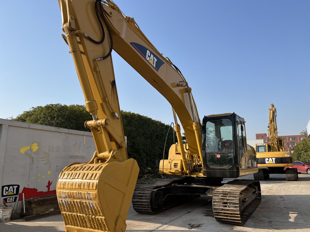 Escavatore cingolato Caterpillar 320CL del 2010, vista anteriore di tre quarti Escavatore cingolato Caterpillar 320CL del 2010, vista anteriore di tre quarti