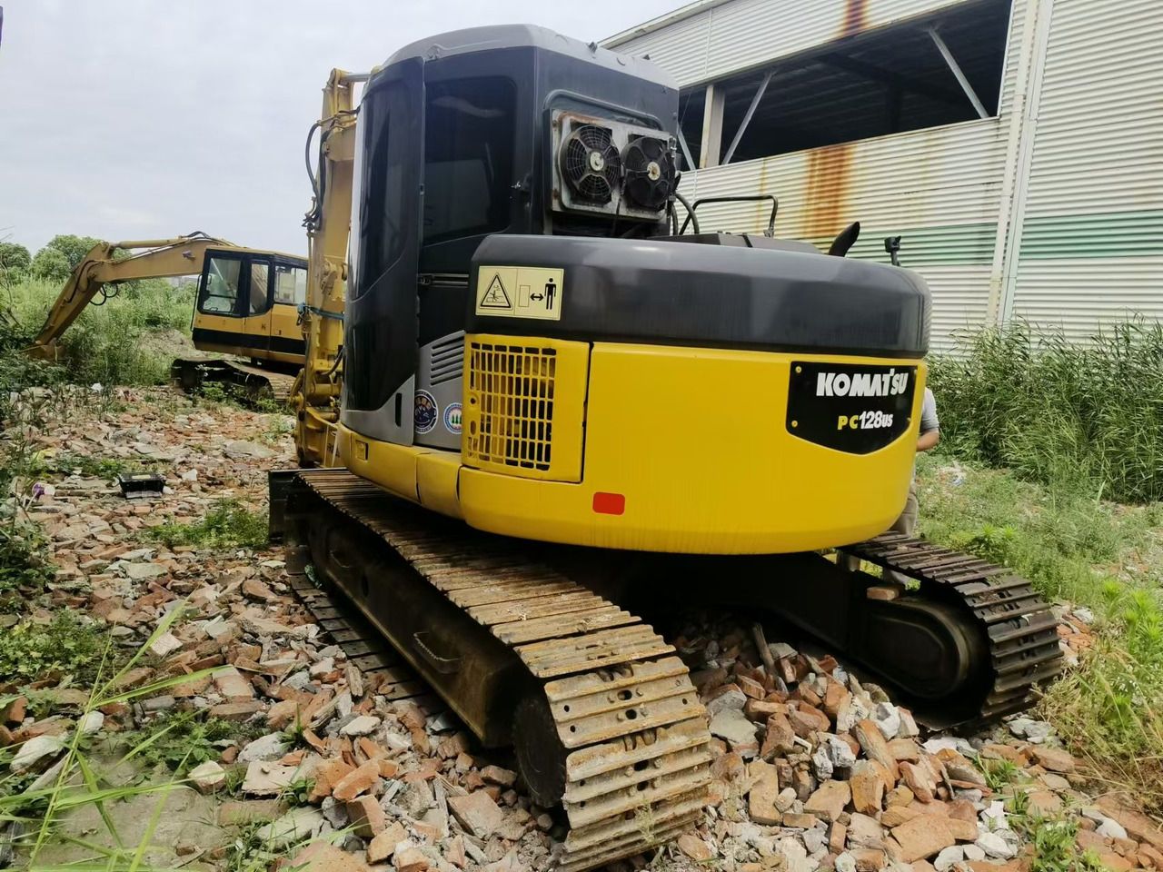Komatsu PC128US excavator, rear three-quarter view Komatsu PC128US excavator, rear three-quarter view