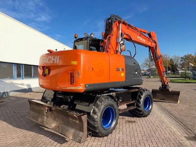 2011 Hitachi ZX140W-3 wheel excavator, rear three-quarter view 2011 Hitachi ZX140W-3 wheel excavator, rear three-quarter view