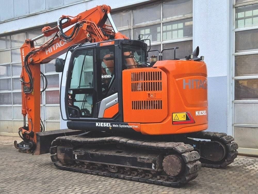2022 Hitachi ZX135US-7 crawler excavator, rear three-quarter view 2022 Hitachi ZX135US-7 crawler excavator, rear three-quarter view