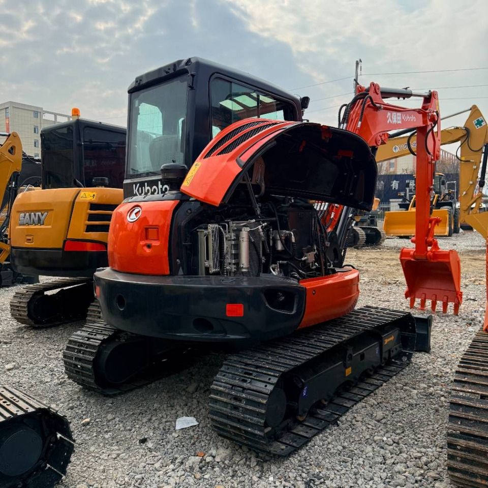2023 Kubota KX165 mini excavator, front three-quarter view with engine cover open 2023 Kubota KX165 mini excavator, front three-quarter view with engine cover open