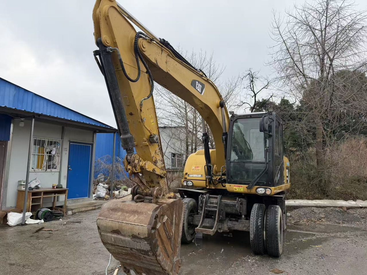 2022 Caterpillar M315D wheel excavator, front three-quarter view