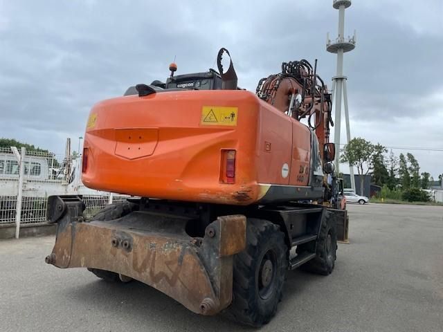 2014 Hitachi ZX140W-5 wheel excavator, rear three-quarter view 2014 Hitachi ZX140W-5 wheel excavator, rear three-quarter view