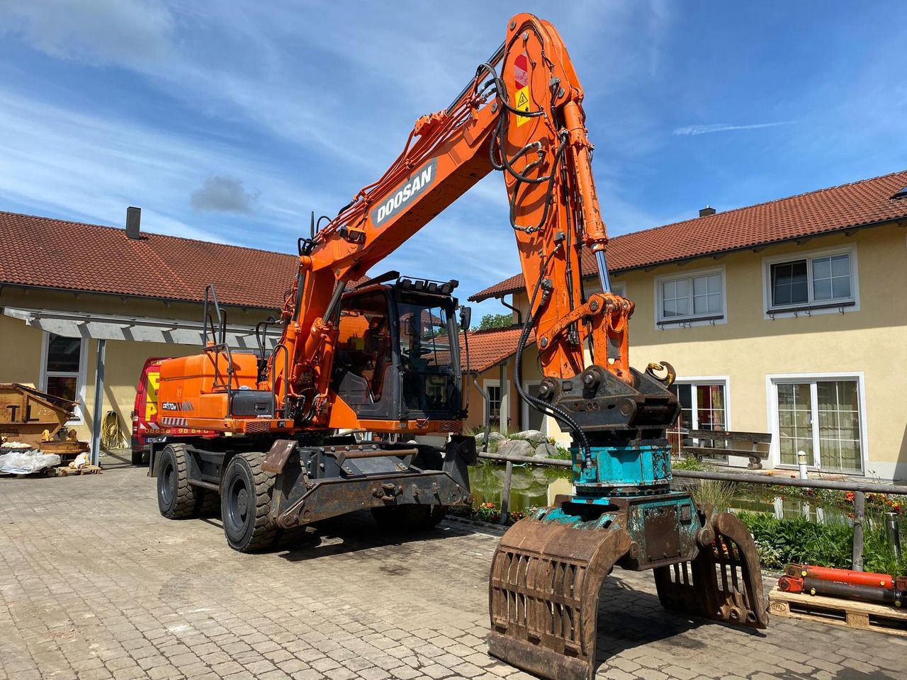 2014 Doosan DX170W wheel excavator, side view with grapple attachment 2014 Doosan DX170W wheel excavator, side view with grapple attachment