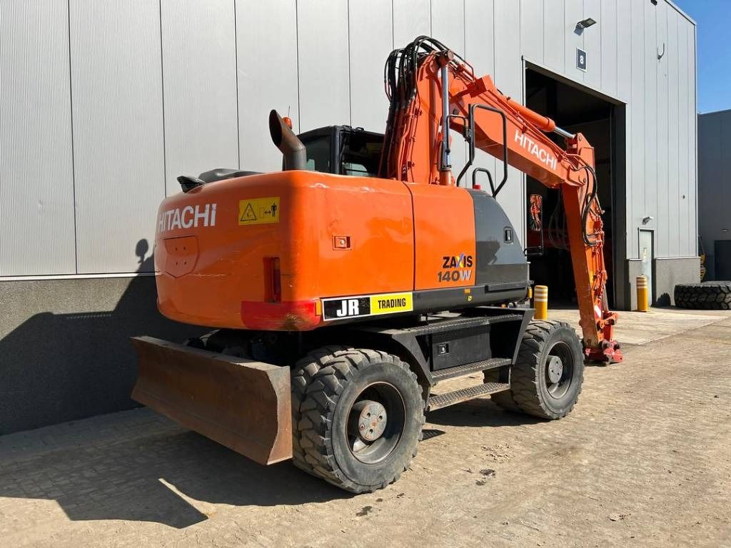 2015 Hitachi ZX140W-5 wheel excavator, rear three-quarter view 2015 Hitachi ZX140W-5 wheel excavator, rear three-quarter view