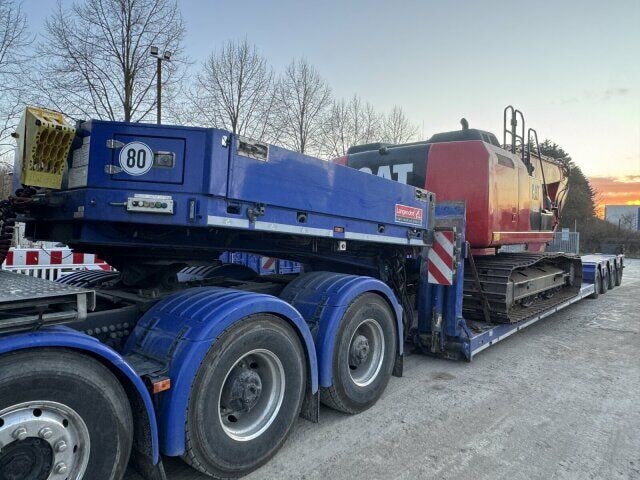 2012 Caterpillar 320E crawler excavator loaded on a flatbed trailer