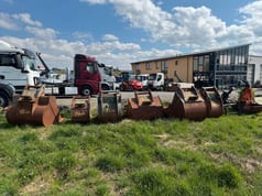 Wheel excavator attachments, row of various excavator buckets and a grapple Wheel excavator attachments, row of various excavator buckets and a grapple