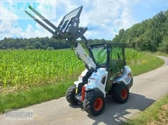 2022 Bobcat L28E mini excavator with pallet forks, side view