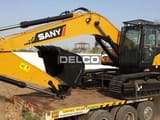 2026 Sany SY240C-9HD Crawler Excavator with a black digging bucket, positioned on the back of a flatbed truck.