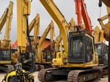 2021 Komatsu PC120 crawler excavator with tree shear attachment, front three-quarter view