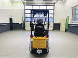 2023 Giant G1200 Mini Excavator with a direct rear view of the yellow engine compartment and operator seat.