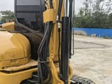 2023 Caterpillar 303.5E mini excavator side view of cab and boom