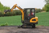 2025 APS KME20 Mini Excavator with its boom and bucket extended to the left, showcasing the undercarriage.