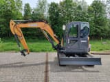 2022 CASE CX60C Mini Excavator from a full side profile, showing the complete undercarriage and rubber tracks.