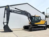 2025 Hyundai R215 Crawler Excavator showing the front three-quarter view with the cab and boom.