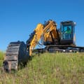 2026 Sany SY155U Crawler Excavator with a black bucket attachment and an operator in the cab.