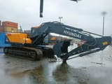 2026 Hyundai R215L SMART Crawler Excavator with a dark gray boom and bucket extended forward.