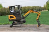 2025 APS KME20 Mini Excavator with its dozer blade lowered and the boom extended forward.