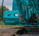 2024 Sunward SWE 335F Mini Excavator with a teal body, highlighting the hydraulic lines and undercarriage.