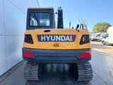 2026 Hyundai R85A Crawler Excavator from the rear, highlighting the orange counterweight with the 'HYUNDAI' logo.