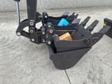 2026 Rhinoceros XN18 Mini Excavator showing a close-up of the black digging bucket with teeth and auxiliary buckets.
