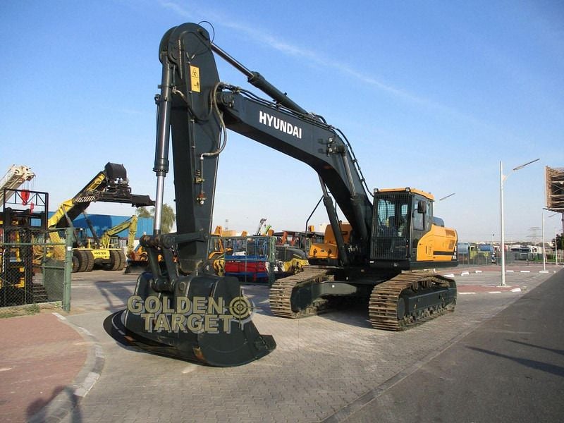 2023 Hyundai HX360L Crawler Excavator with a black boom and arm extended forward, showcasing the heavy-duty bucket. 2023 Hyundai HX360L Crawler Excavator with a black boom and arm extended forward, showcasing the heavy-duty bucket.