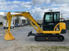 2022 Komatsu PC58-8 Crawler Excavator from the left side, highlighting the yellow body and black tracks.