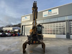 2016 Caterpillar MH3022 wheel excavator, front view with grapple attachment