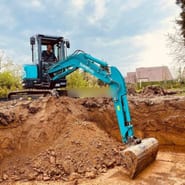 2026 Sunward SWE35UF Mini Excavator with a teal body and a side view of the cab and operator.