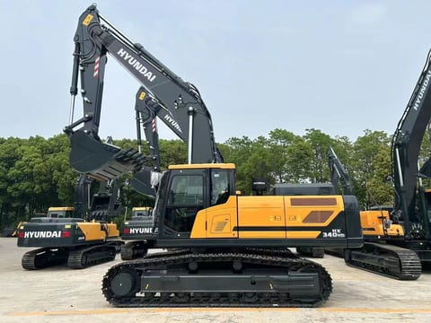2026 Hyundai HX340HD Crawler Excavator with a dark grey boom and arm extended forward, showing the bucket. 2026 Hyundai HX340HD Crawler Excavator with a dark grey boom and arm extended forward, showing the bucket.
