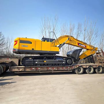 2026 XCMG XE335G Crawler Excavator with its yellow boom and bucket extended over a trailer.